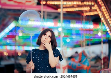 Woman Holding a Balloon at Local Carnival Fair. Girl experiencing childhood nostalgia attending an amusement park event 
