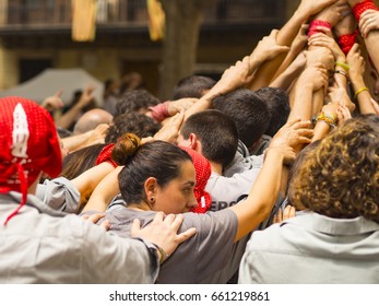 Woman Holding The Base Of The Typical Catalan Human Pyramid Called Castellet, In Mataró, Barcelona, ??Spain.