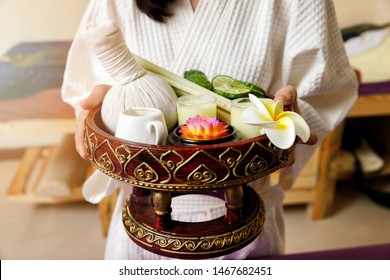 Woman Holding Basket Of Kaffir Lime Or Bergamot, Lemongrass And Other Thai Herbs In Thai Spa And Massage Shop.