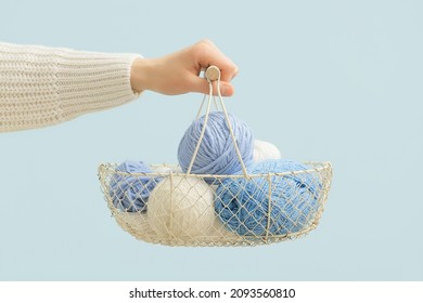 Woman Holding Basket With Knitting Yarn On Color Background