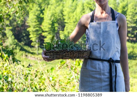 woman holding a basket with spicy herbs
