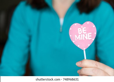 Woman holding a Be Mine Valentine candy sucker