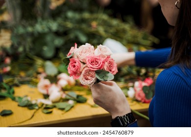 The woman is holding a beautiful bouquet of pink hybrid tea roses, creating a happy and elegant look for a special event. Her hands are adorned with delicate flower petals from the garden roses - Powered by Shutterstock