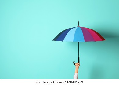 Woman holding beautiful umbrella on color background with space for design - Shutterstock ID 1168481752