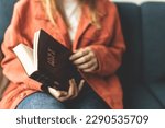 A woman is holding a Bible and praying. Studying the Holy Scriptures. Spiritual growth. Faith and spirituality. Bible study and prayer. Oration.