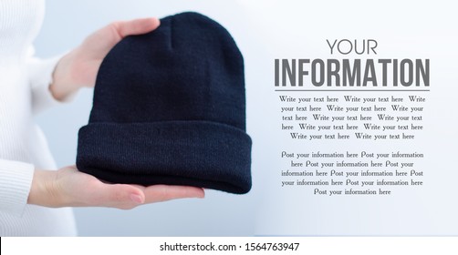 Woman Holding Black Warm Knit Hat In Hand On Light Background