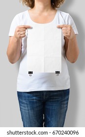 Woman Holding A Blank A4 Poster Mockup Isolated On A Gray Background. 