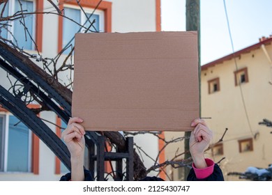 Woman Holding Blank Cardboard Box, Protesting Something. Copy Space For Text On Cardboard Box.