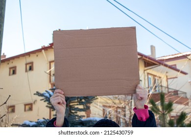 Woman Holding Blank Cardboard Box, Protesting Something. Copy Space For Text On Cardboard Box.