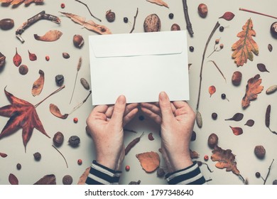 Woman Holding Blank Post Mail Envelope Mock Up With Autumn Arrangement Flat Lay Top View Copy Space