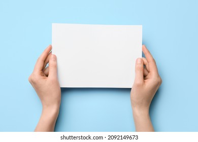 Woman holding blank sheet of paper on color background, closeup - Shutterstock ID 2092149673