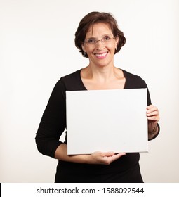 Woman Holding Up A Blank White Sign With Room For Your Copy. Advertisement Concept.