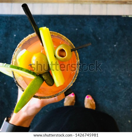 Woman Holding Bloody Mary Cocktail Alcohol Drink in Hand with Vegetable Garnish Top View
