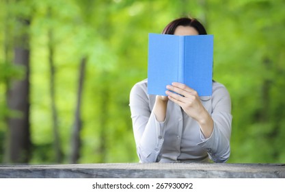 Woman Holding Book In Front Of Her Face