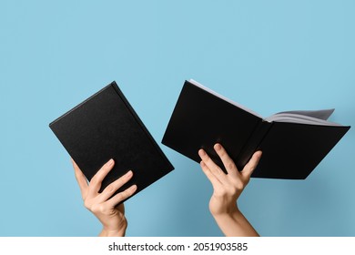 Woman holding books on color background