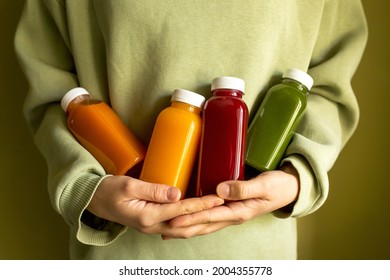 The woman is holding bottles of freshly squeezed juice in her hands. The concept of a healthy lifestyle, diet or detox, body care.