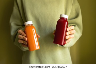 The woman is holding bottles of freshly squeezed juice in her hands. The concept of a healthy lifestyle, diet or detox.