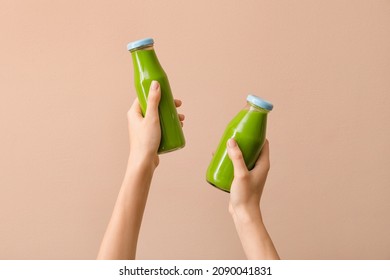 Woman holding bottles of healthy green smoothie on color background - Powered by Shutterstock