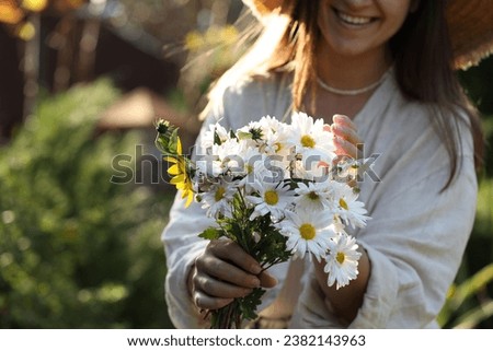 Woman holding bouquet of beautiful white chamomile flowers outdoors, closeup. Space for text