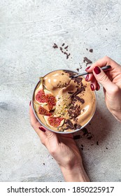 Woman Holding Bowl Of Chocolate Smoothie With Figs And Hemp Seeds, Gray Background. Healthy Vegan Food Concept.