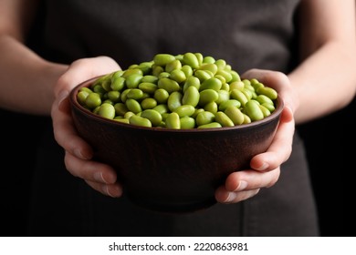 Woman Holding Bowl Of Edamame Beans On Dark Background, Closeup