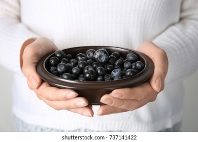 Woman Holding Bowl Of Fresh Acai Berries, Closeup