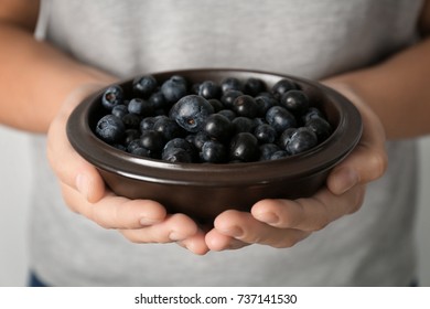 Woman Holding Bowl Of Fresh Acai Berries, Closeup