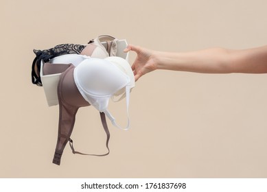 Woman is holding a bra in her hand. Brassiere choice.