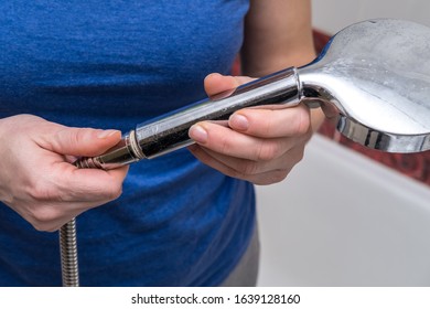 Woman Is Holding A Broken Shower Sprinkler Head In Her Hands And Changes To A New One