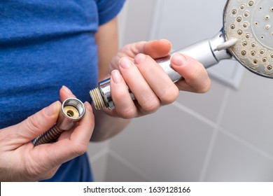 Woman Is Holding A Broken Shower Sprinkler Head In Her Hands And Changes To A New One