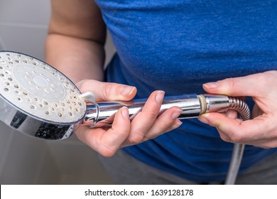 Woman Is Holding A Broken Shower Sprinkler Head In Her Hands And Changes To A New One