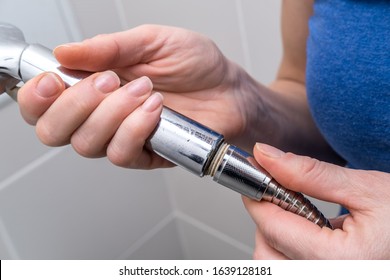 Woman Is Holding A Broken Shower Sprinkler Head In Her Hands And Changes To A New One