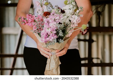 Woman Holding Bunch Of Cottage Garden Flowers In Pink And Purple