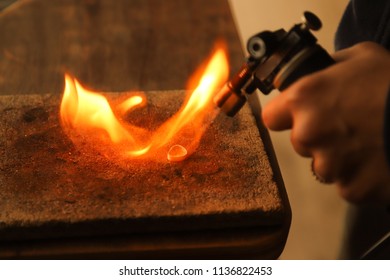 Woman Holding A Butane Torch Flame, Heating Jewelry To Solder.