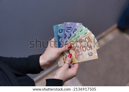 Woman is holding Canadian dollars in her hands. Canadian money in different nominals Foto d'archivio © 