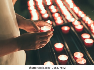 Woman Holding Candle Near Altar In Church.