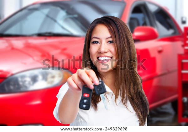 Woman holding a\
car key. Auto repair\
service