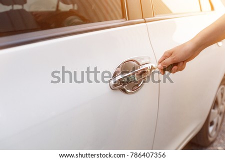Woman holding car key to opening car door. Women hand holding car keys to unlock or lock the car.
