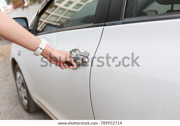 Woman holding car key to opening\
car door. Women hand holding car keys to unlock or lock the\
car.