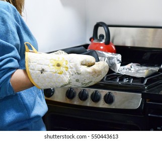 Woman Holding Casserole Dish Of Mexican Cheese Dip With Oven Mitts