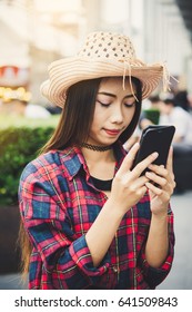 Woman Holding A Cell Phone For Navigation Data During Her Summer Trip.