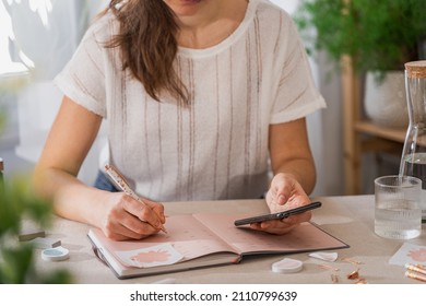 Woman holding a cell phone and plan Schedule Calendar and , work online at home. Women hand planning daily appointment and note holiday trip in diary. 2022 Calendar reminder  Plan a week