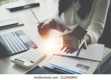 A woman holding and checking house model .Real Estate House Appraisal And Inspection and Insurance concept. - Shutterstock ID 2123500892