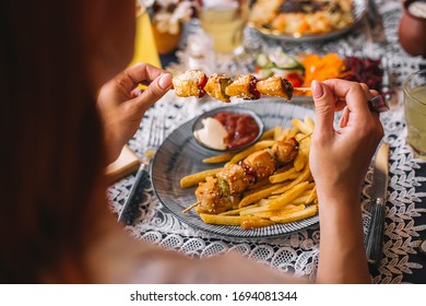 Woman Holding Chicken Pieces On Skewers Sprinkled With Sesame