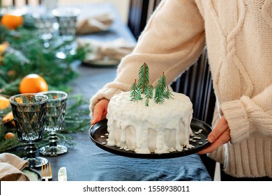 Woman Holding Christmas Cake With Cream Over A Table