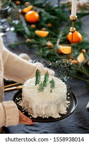 Woman Holding Christmas Cake With Cream Over A Table