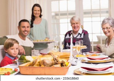 Woman Holding Christmas Dinner With Family At Dinning Table At Home In The Living Room