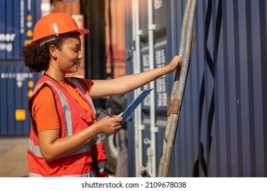 ฺิฺBlack Woman Holding A Clipboard Wearing An Accident-preventing Engineer's Hat Walks Up The Stairs To Inspect The Containers At The Container Yard Before Sending Them Abroad.