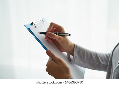 woman holding clipboard and writing on it, concept of work with documents and information - Shutterstock ID 1486363730