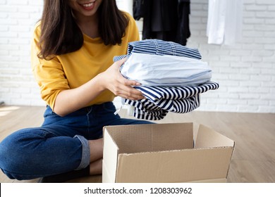 Woman holding Clothes with Donate Box In her room, Donation Concept. - Shutterstock ID 1208303962